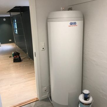 Varmtvannstank som står rett på innsiden av et rom som går ut i en stue