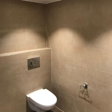 Toalett som er lukket med dorullholder som henger på veggen