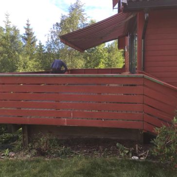 Rødt rekkverk på terrasse til rødt hus